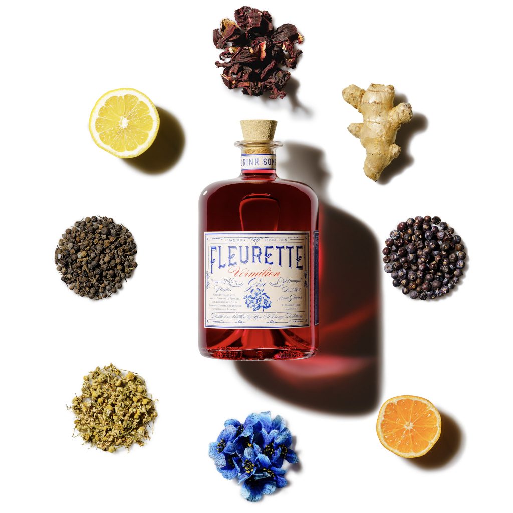 A bottle of Fleurette Vemilion gin pictured with included botanicals