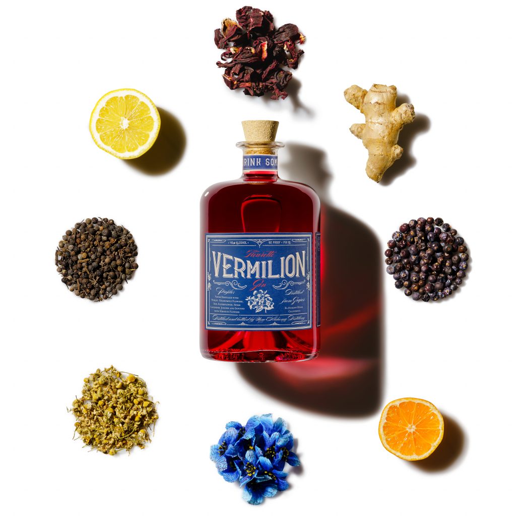 A bottle of Fleurette Vemilion gin pictured with included botanicals